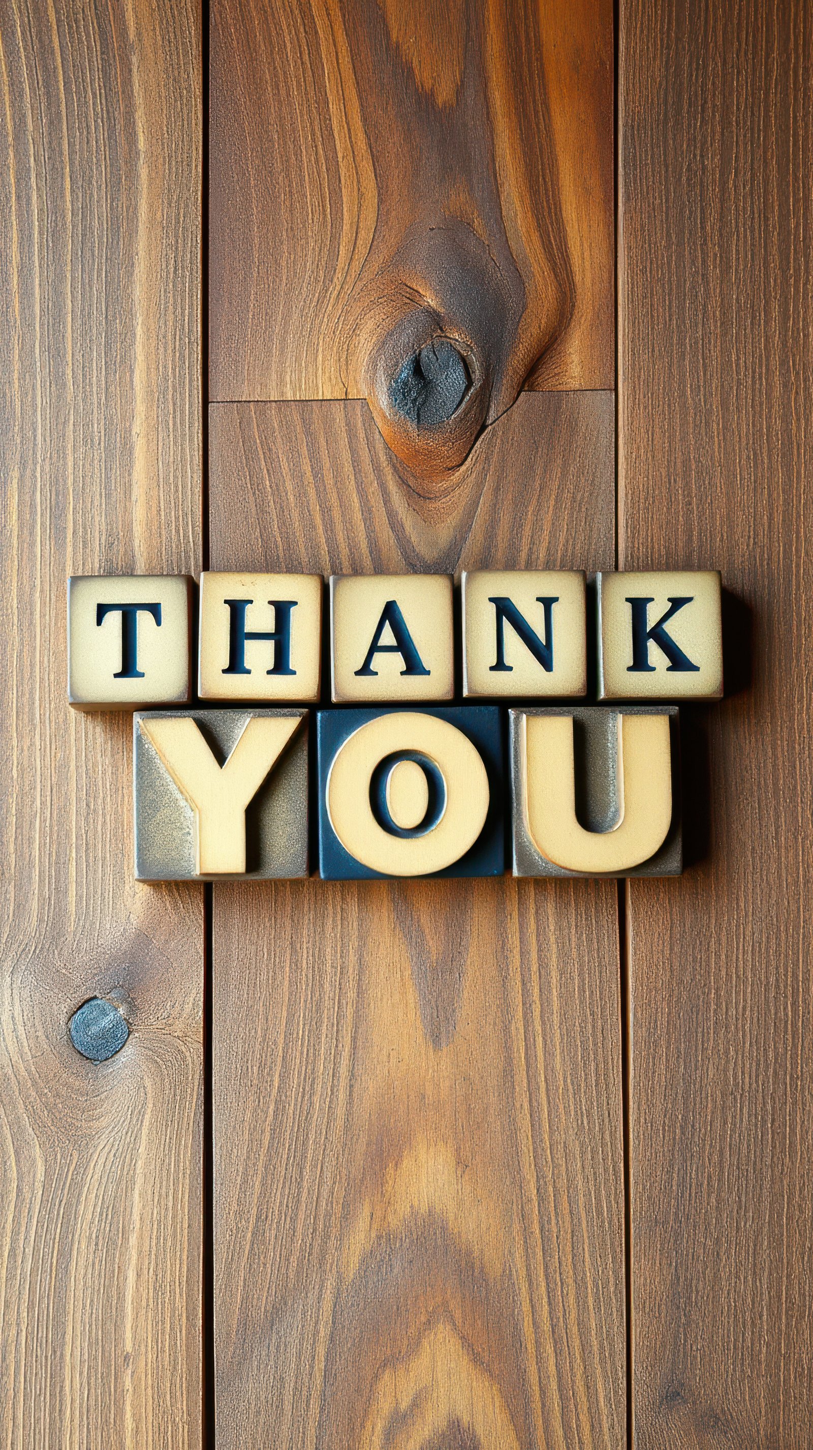 Thank you message created with vintage printing blocks displayed on wooden background